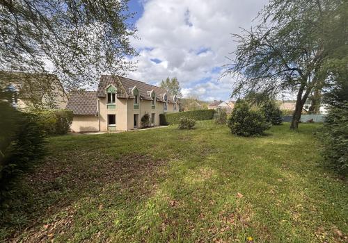Façade de la résidence entourés d'arbres et de verdure.